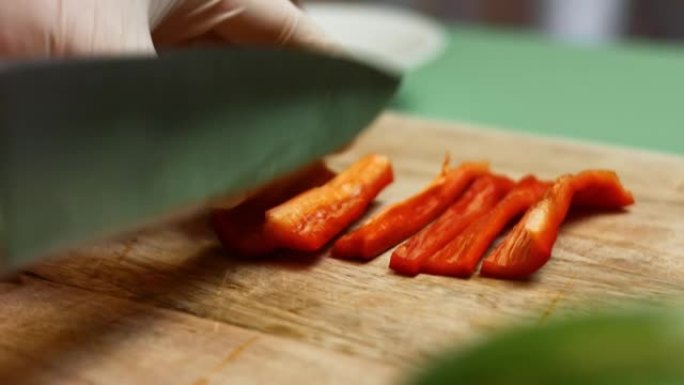 厨师的手切成新鲜的甜红甜椒。油炸玉米饼的制作过程