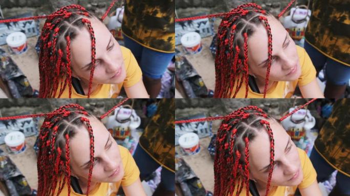 非洲妇女编织非洲辫子与红色Kanekalon户外，桑给巴尔非洲