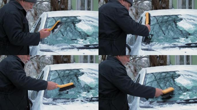 资深人士手握刮冰器清洁挡风玻璃