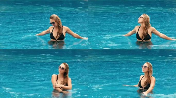 宽大的中拍美女在酒店的游泳池里喝蓝色鸡尾酒酒精酒。室外游泳池中性感女孩的肖像。