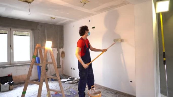 男子用防护面罩粉刷公寓墙壁