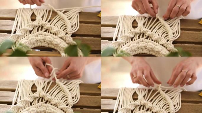 在家庭作坊中，妇女的双手在编织花边。手工制作的概念。