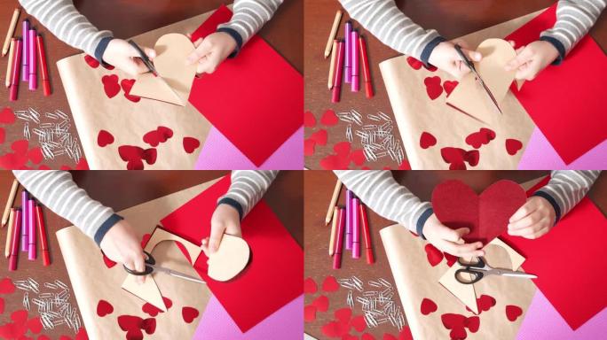 孩子的手用剪刀从彩纸上切出心形卡片的特写镜头。儿童创造力和情人节概念。