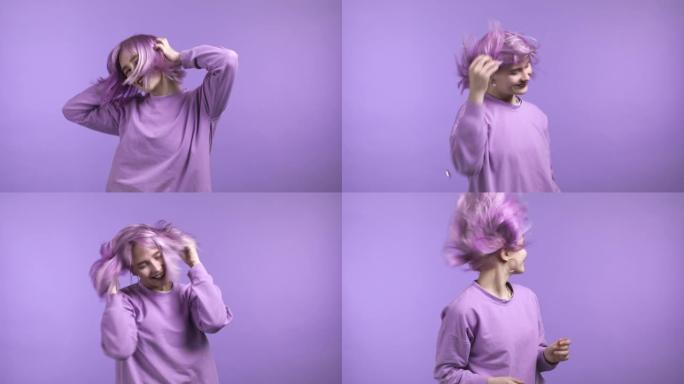 紫色发型的迷人女人在紫色工作室背景上跳舞，她的头发从气流中飘动。穿五颜六色衣服的女孩。积极的情绪。