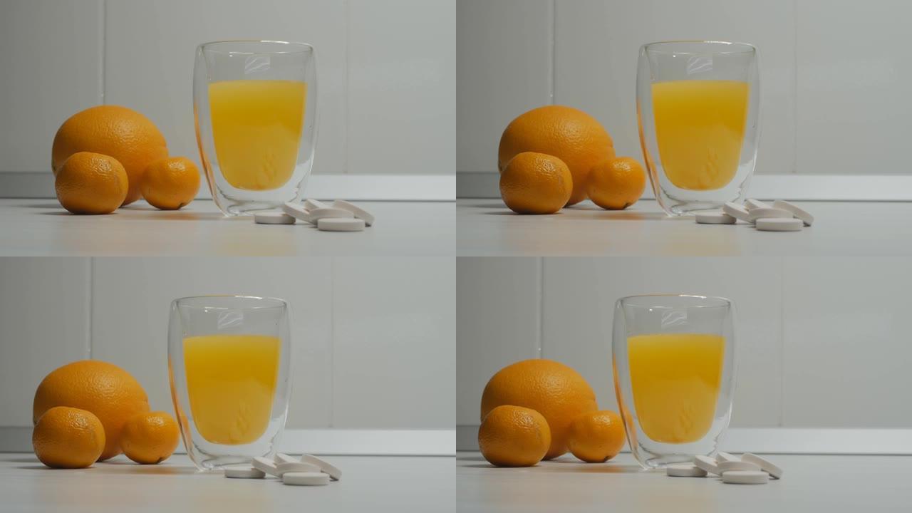 多莉用双杯玻璃杯射击，其中柑橘维生素c嘶嘶声和橘子躺在旁边。靠近一杯阿司匹林片。4k。特写