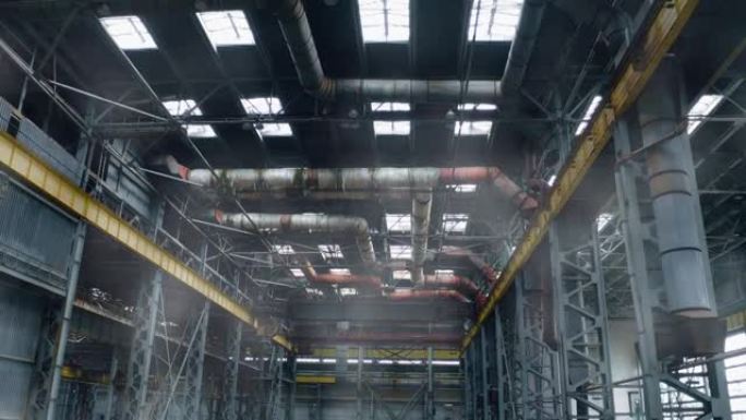 蒸汽或烟雾在大型旧工厂的车间中上升