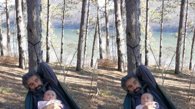 父亲和他刚出生的婴儿在吊床上摇摆，在大自然中一起玩耍和大笑。在新型冠状病毒肺炎大流行期间，花时间在松