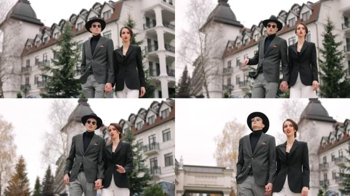 一个男人和一个女人正在走路聊天。他们穿着时髦。美丽的建筑背景。4 k。
