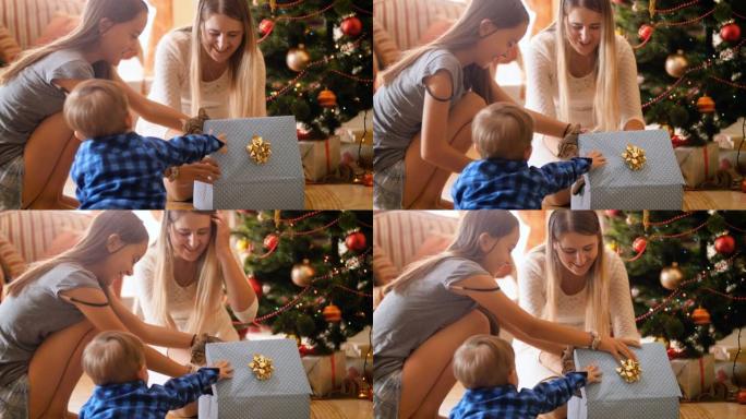 快乐家庭的4k镜头打开圣诞礼物和礼物。可爱的小猫走出盒子。家人在寒假和庆祝活动中玩得开心。