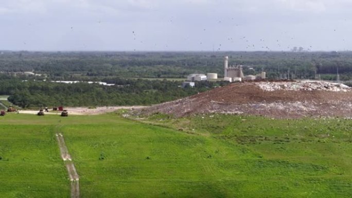 美国佛罗里达州垃圾填埋场卫生场地和废物管理厂的鸟瞰图。一大群秃鹰正在垃圾堆上飞来飞去。带有平移相机运