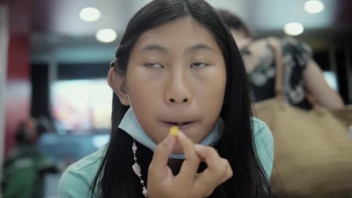 快乐的亚洲女孩在垃圾食品餐厅吃法式油炸与家庭，生活方式的概念。