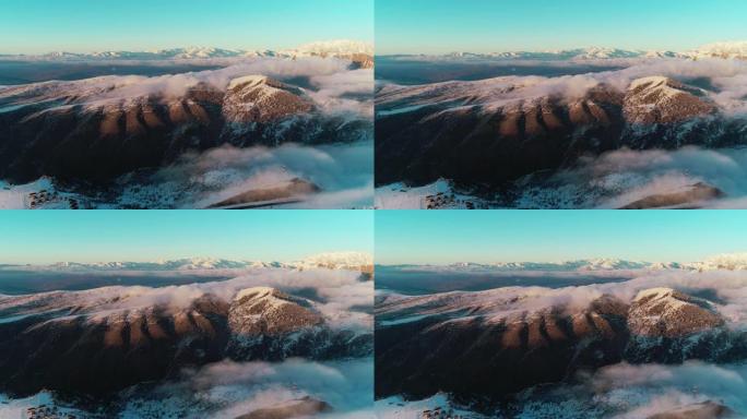 无人机摄像机在日落时穿越中亚雪山上空的云层拍摄