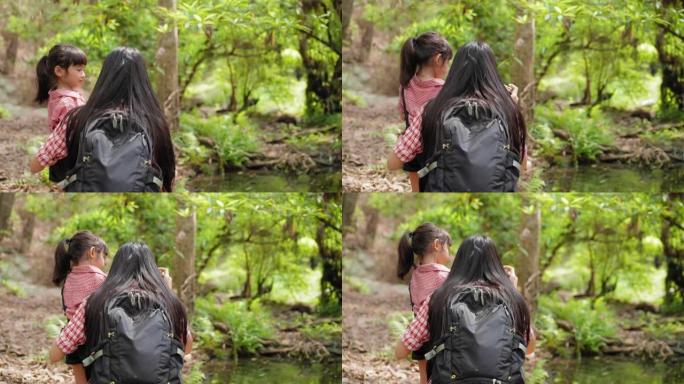 孩子的冒险和探索，后视: 亚洲女孩与背包客母亲自然旅行，休闲活动看野生动物，徒步旅行时孔雀群，在热带