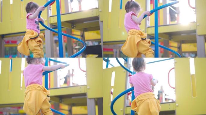 孩子。小女孩在操场上玩耍。攀爬架