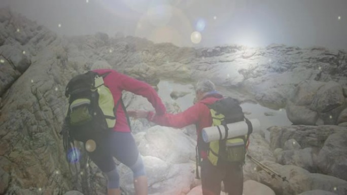 快乐的高加索高级夫妇在山上徒步旅行，穿越快速移动的雪花