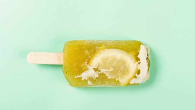 顶视图新鲜的白桃和茉莉花味冰棒，在4K分辨率的浅绿色背景下，带有柠檬融化的时光倒流