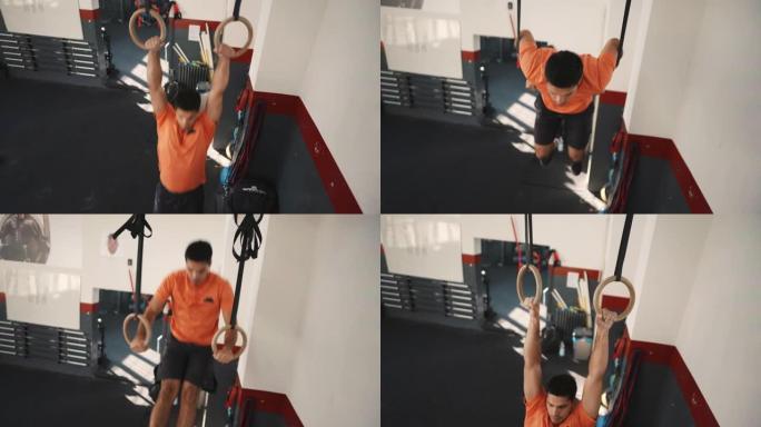 年轻的运动男子在健身房的体操环上锻炼