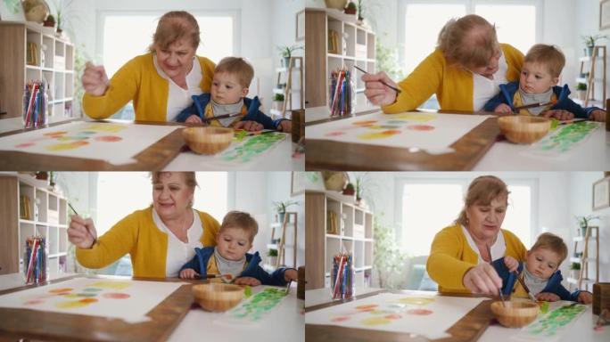 开朗的祖母和她的小孙子一起画画
