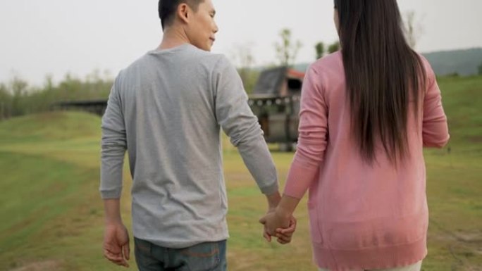 亚洲夫妇在公园散步时手牵手。