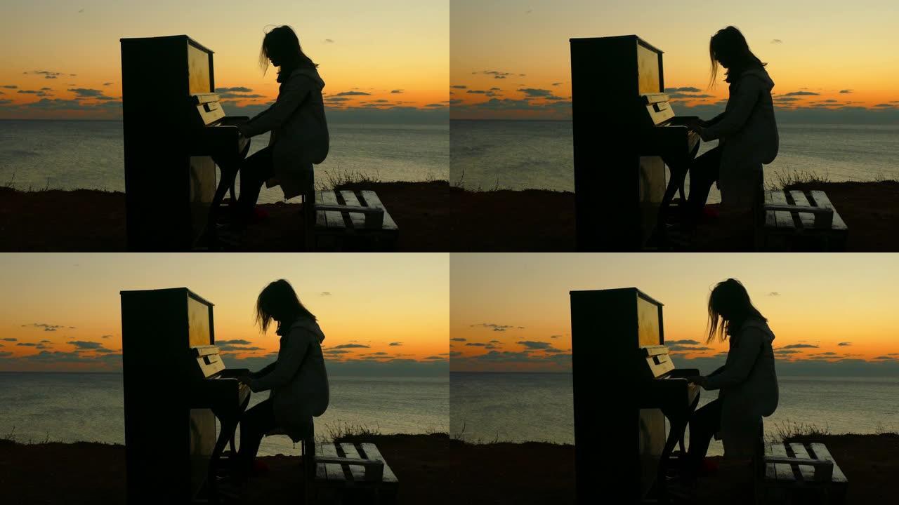 日落时在海岸上弹钢琴的女孩的剪影