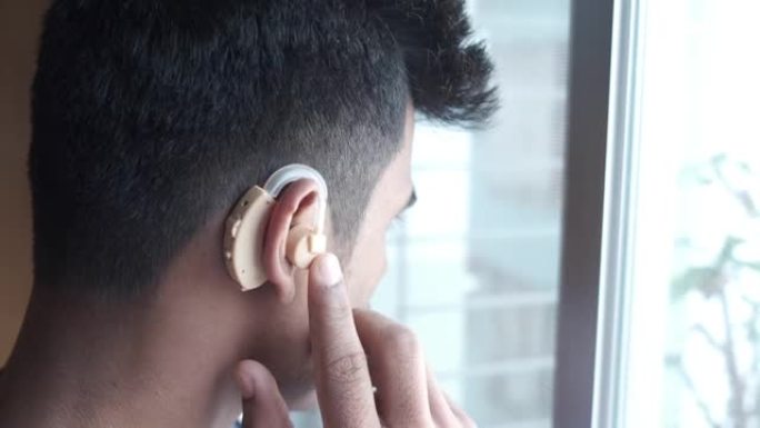助听器概念，一个有听力问题的年轻人。