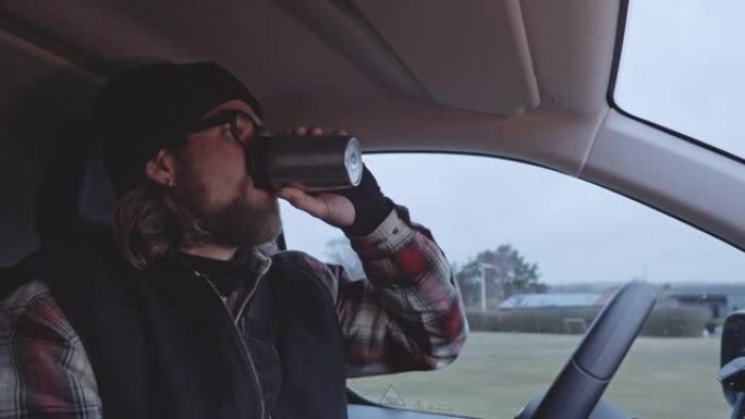 戴眼镜的大胡子男人开车喝咖啡