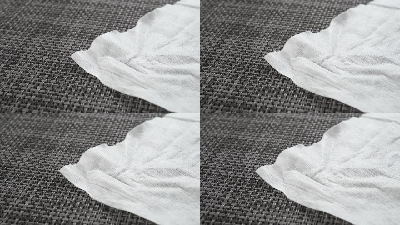 灰色塑料纹理表面的白色湿巾