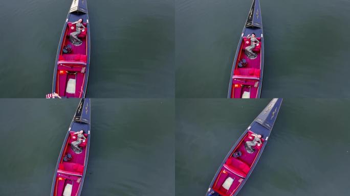 吊篮里漂亮的模特。女人在水上漂浮的船上享受假期。豪华女子在贡多拉航行。鸟瞰图。
