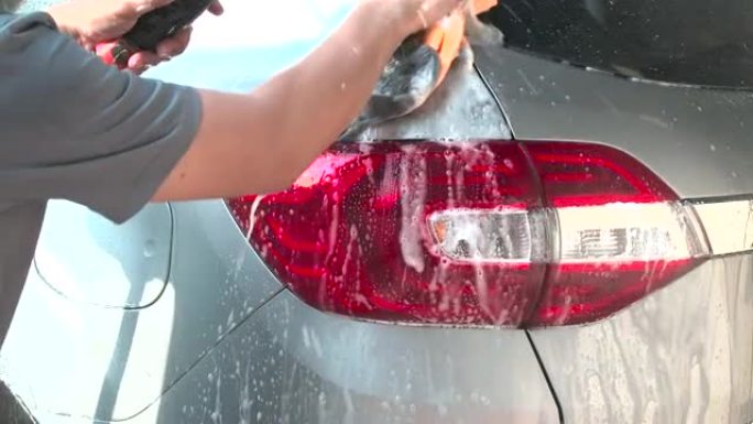 通过清洗洗发水和喷水，水清洗汽车来关闭一名男子洗车