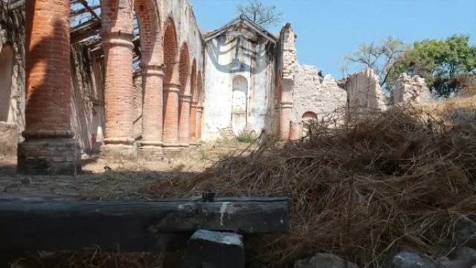 坦噶尼喀湖沿岸的破旧教堂穿过拱门进入老教堂，显示倒塌的墙壁和屋顶上的碎屑。