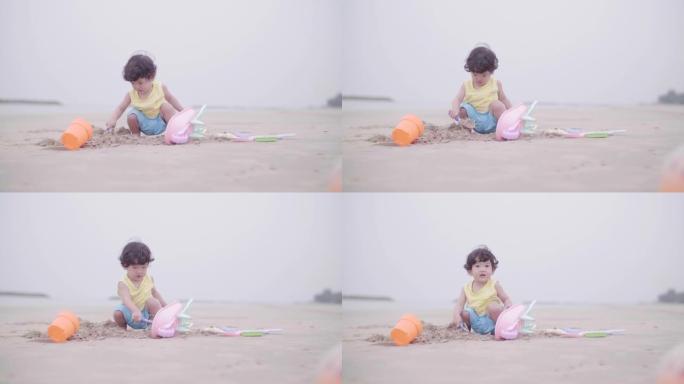 可爱的男孩在沙滩上玩沙子和快乐。
