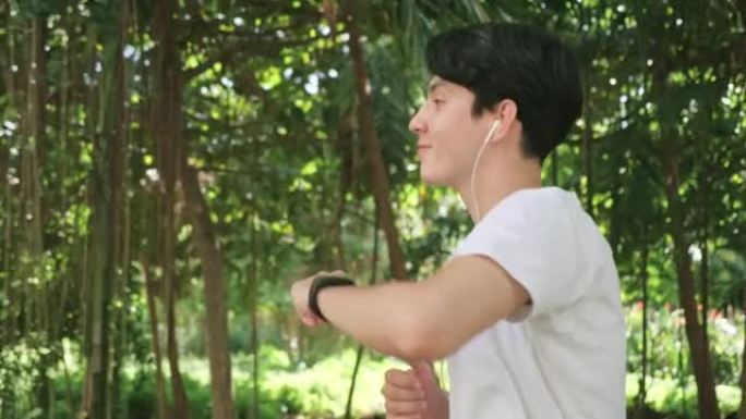 西安人在公共绿色公园的公园里用智能手表跑步和检查脉搏