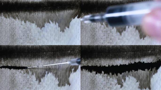 用注射器针头在湿的纹理纸表面上散布着笔直的墨水线。慢动作。特写