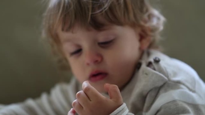 蹒跚学步的男孩捡鼻子。孩子挑鼻子