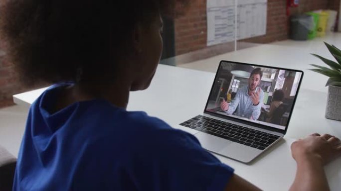 非裔美国妇女在办公室的笔记本电脑上与男同事进行视频通话