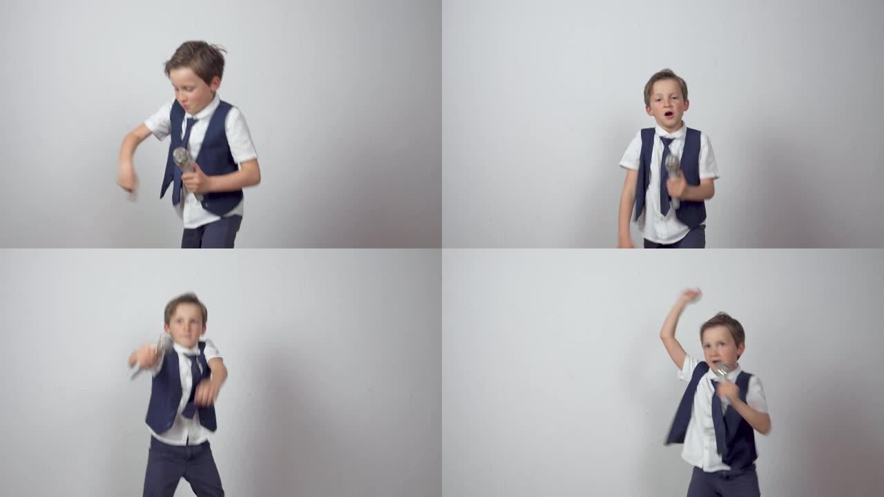 时髦的小男孩用麦克风唱歌跳舞