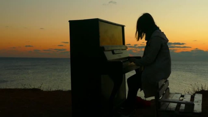 日落时海滩上有钢琴的女孩