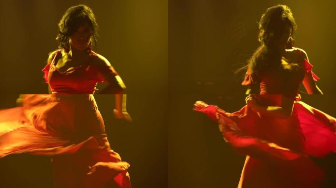 穿着红色长裙的黑发女人在黑暗烟熏工作室的黄色霓虹灯背景下跳舞热情的弗拉门戈舞。特写阿根廷女舞者旋转跳