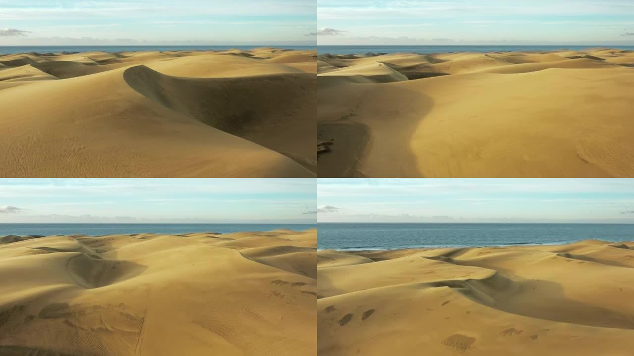 炎热干旱沙漠中的金色沙丘。飞越沙质沙漠到达水面。