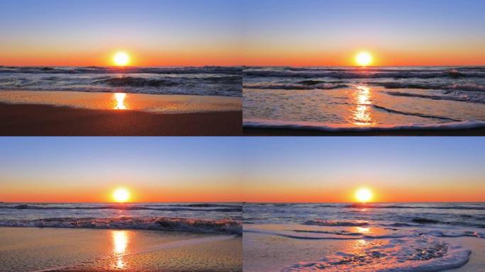 五颜六色的海洋海滩日出。海浪洗沙。