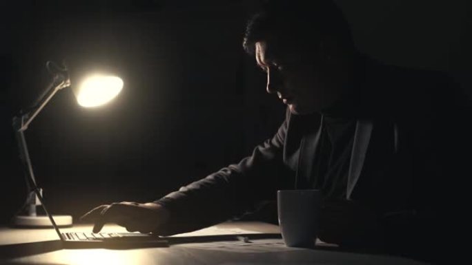 夜间工作主管使用笔记本电脑喝咖啡