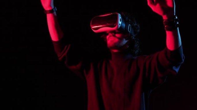 头上戴着VR头盔的人在红蓝灯光下玩，在线游戏
