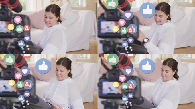 数字社交媒体爱与喜欢图标的动画在家里录制vlog的女性视频记录器上