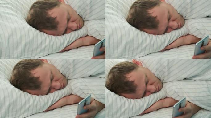 醒来后的第二天早上，一个男人躺在床上，看着手机里的新闻，相机跟踪