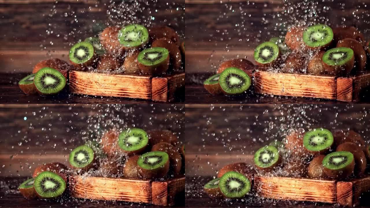 超慢动作在木托盘中的猕猴桃上落下水滴。以1000 fps的高速相机拍摄。