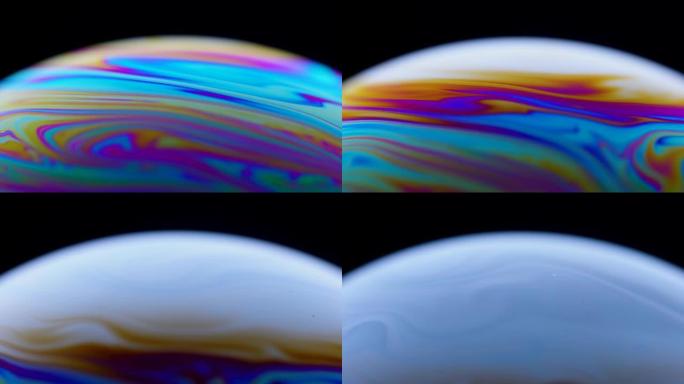 彩色的肥皂泡的特写表面，带有抽象的迷幻背景和黑色背景上的图案。鲜艳的彩虹色在怪异和奇怪的图案。特写。