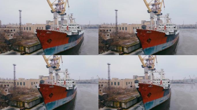 废弃沉没的生锈船多年停泊在港口，货物多吨位起重机和商业建筑