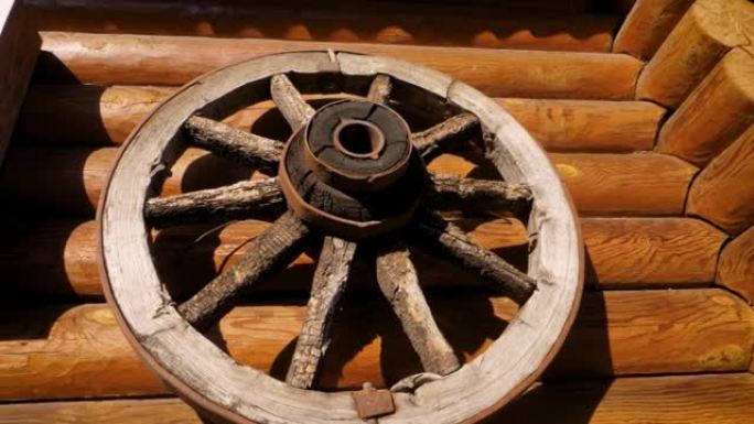 马车或马车上的古董轮挂在原木墙上。