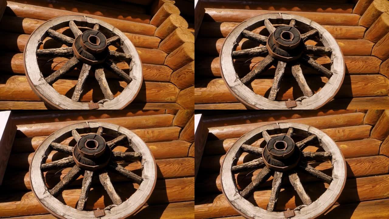 马车或马车上的古董轮挂在原木墙上。