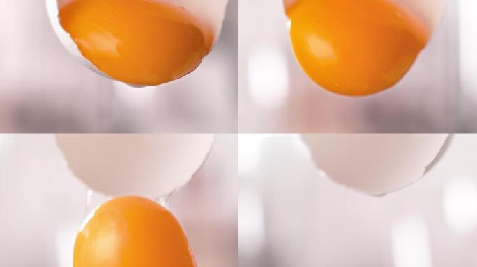 分离的蛋黄在宏观和慢动作中从切成两半的蛋壳中脱落